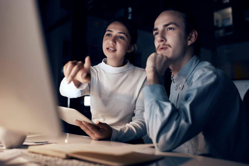 Two people sitting at a desktop computer exploring cybersecurity career
